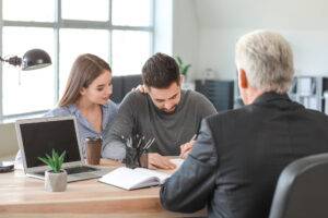 Paar unterschreibt Dokumente beim Anwalt