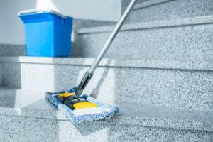 Treppenhaus, Stufen werden gereinigt mit Wischer.