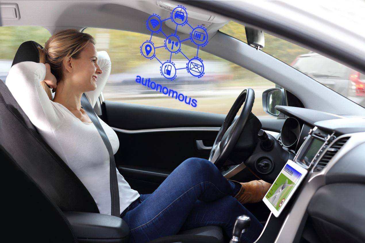 Eine Frau lehnt sich entspannt im Auto zurück, während das Fahrzeug autonom fährt – ein Kontrast zum Schleuderkurs Winterthur, wo echte Kontrolle trainiert wird.