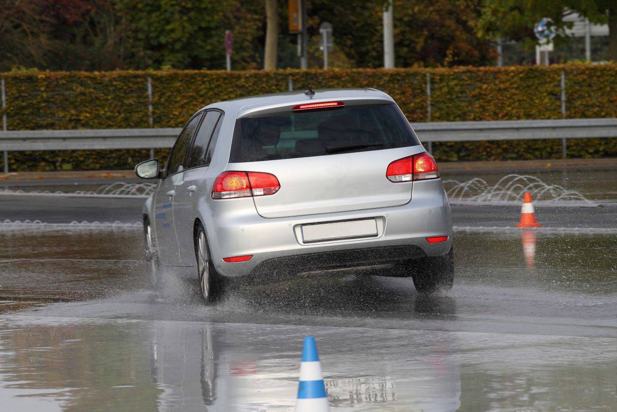 Ein silbernes Auto auf nasser Fahrbahn beim Schleudern – realistische Übung im Schleuderkurs Winterthur zur Verbesserung der Fahrtechnik.