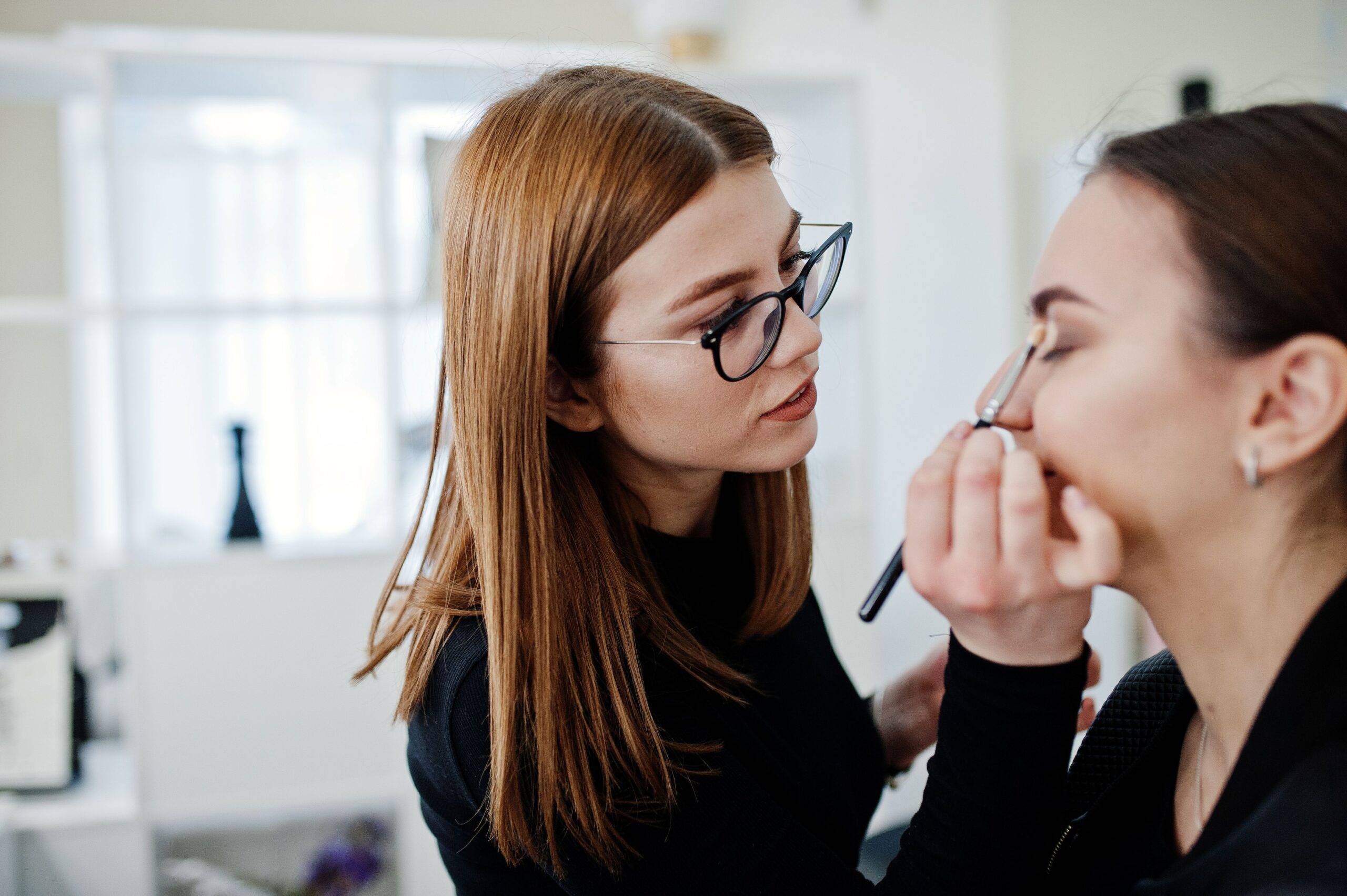 Make-up-Artistin arbeitet in ihrem Beauty-Visage-Studio-Salon. Frau, die sich von einem professionellen Make-up-Meister bewirbt. Konzept eines Beauty-Clubs.
