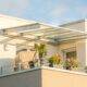Terrassenüberdachung Frankfurt: moderne Glasüberdachung auf dem Balkon einer Stadtwohnung bei Sonnenschein