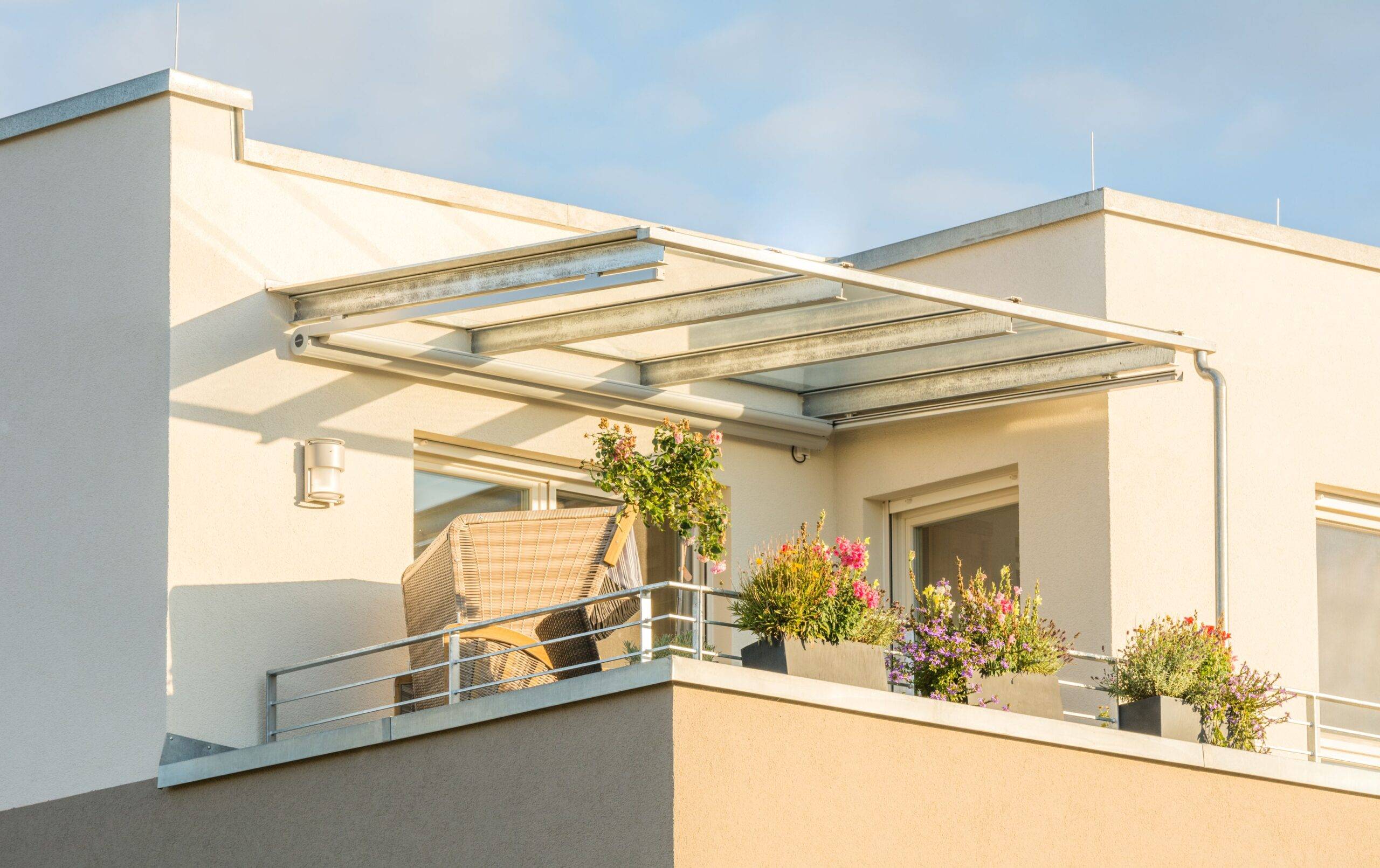 Terrassenüberdachung Frankfurt: moderne Glasüberdachung auf dem Balkon einer Stadtwohnung bei Sonnenschein