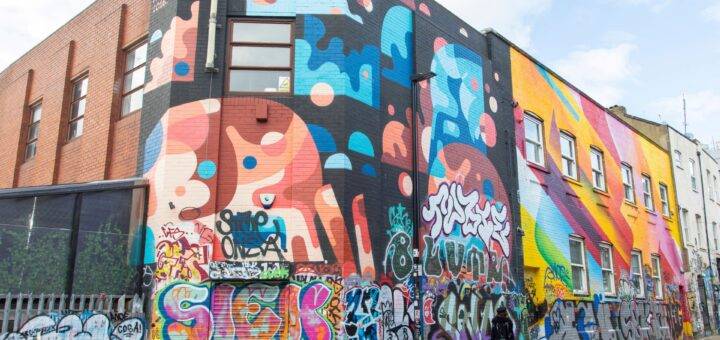 Bunte Hausfassade mit großflächiger Wandgestaltung von Graffiti Künstlern