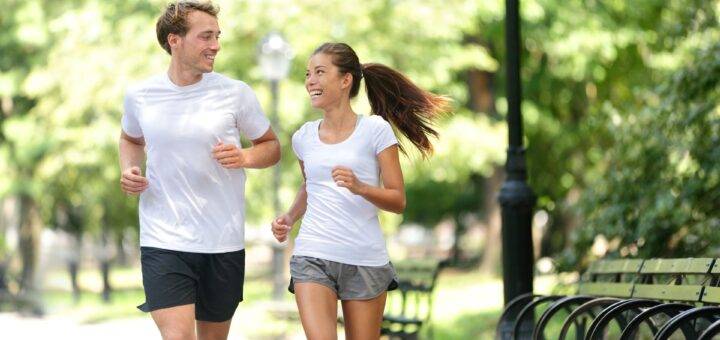 Paar joggt im Stadtpark bei sonnigem Wetter