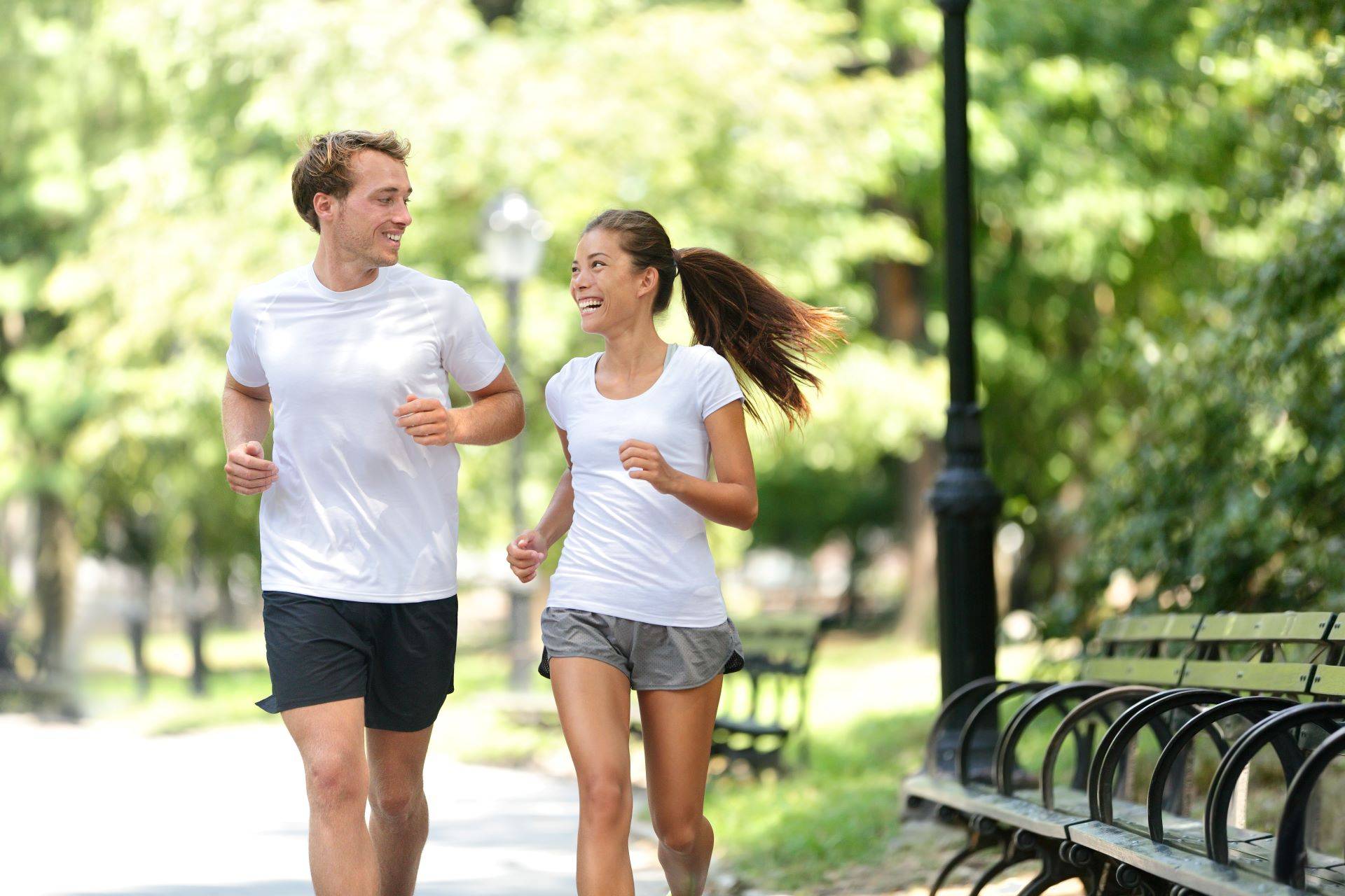 Paar joggt im Stadtpark bei sonnigem Wetter