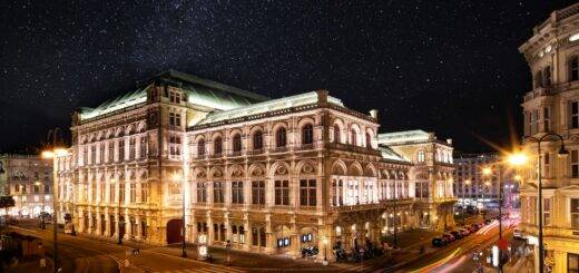 Beleuchtete Wiener Staatsoper bei Nacht mit Sternenhimmel – klassisches Wahrzeichen im naechtlichen Stadtbild