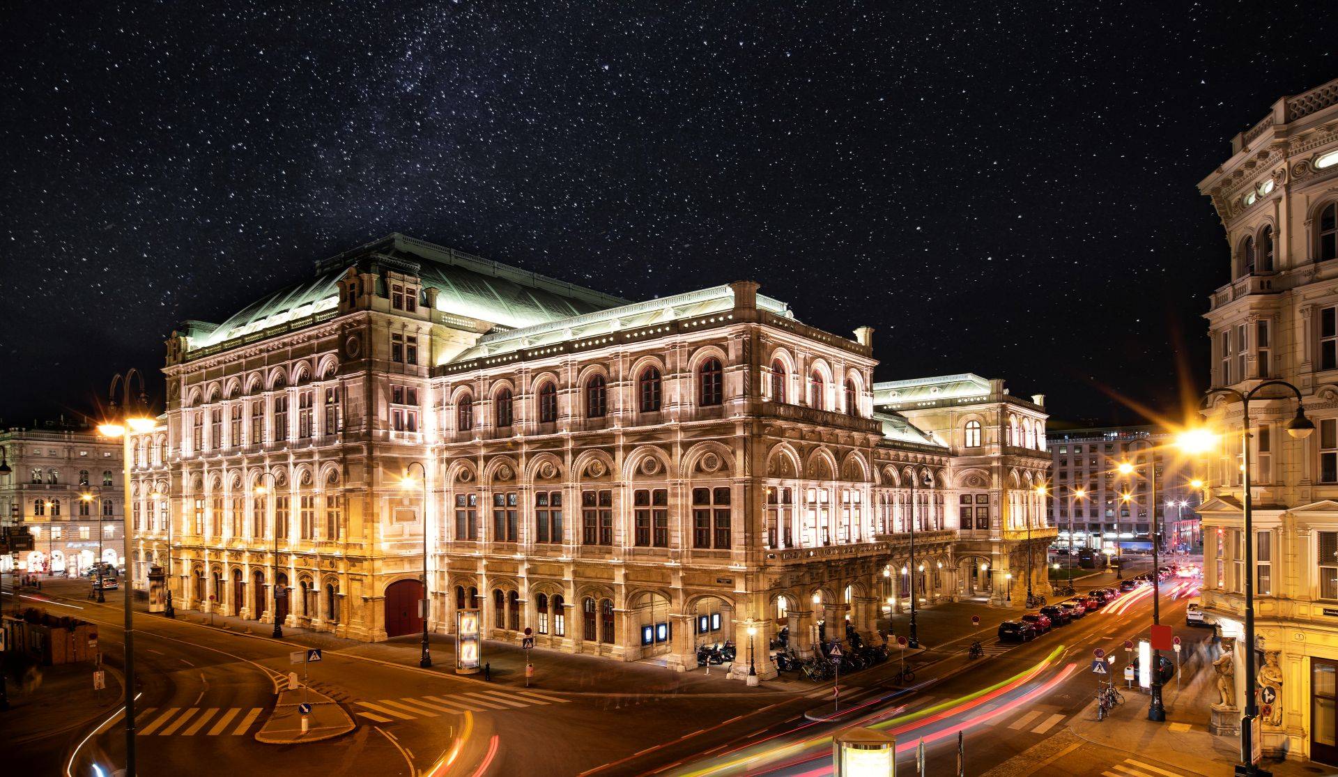 Beleuchtete Wiener Staatsoper bei Nacht mit Sternenhimmel – klassisches Wahrzeichen im naechtlichen Stadtbild
