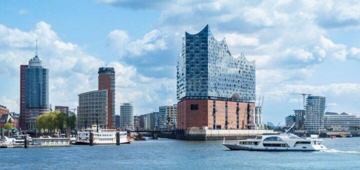 Elbphilharmonie in Hamburg bei einer Klassenfahrt vom Hafen aus gesehen, mit Ausflugsschiffen im Vordergrund