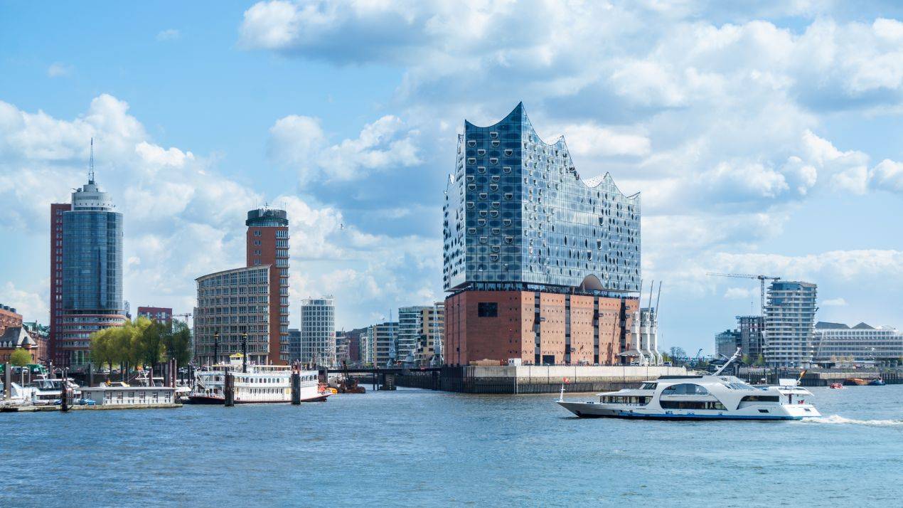 Elbphilharmonie in Hamburg bei einer Klassenfahrt vom Hafen aus gesehen, mit Ausflugsschiffen im Vordergrund