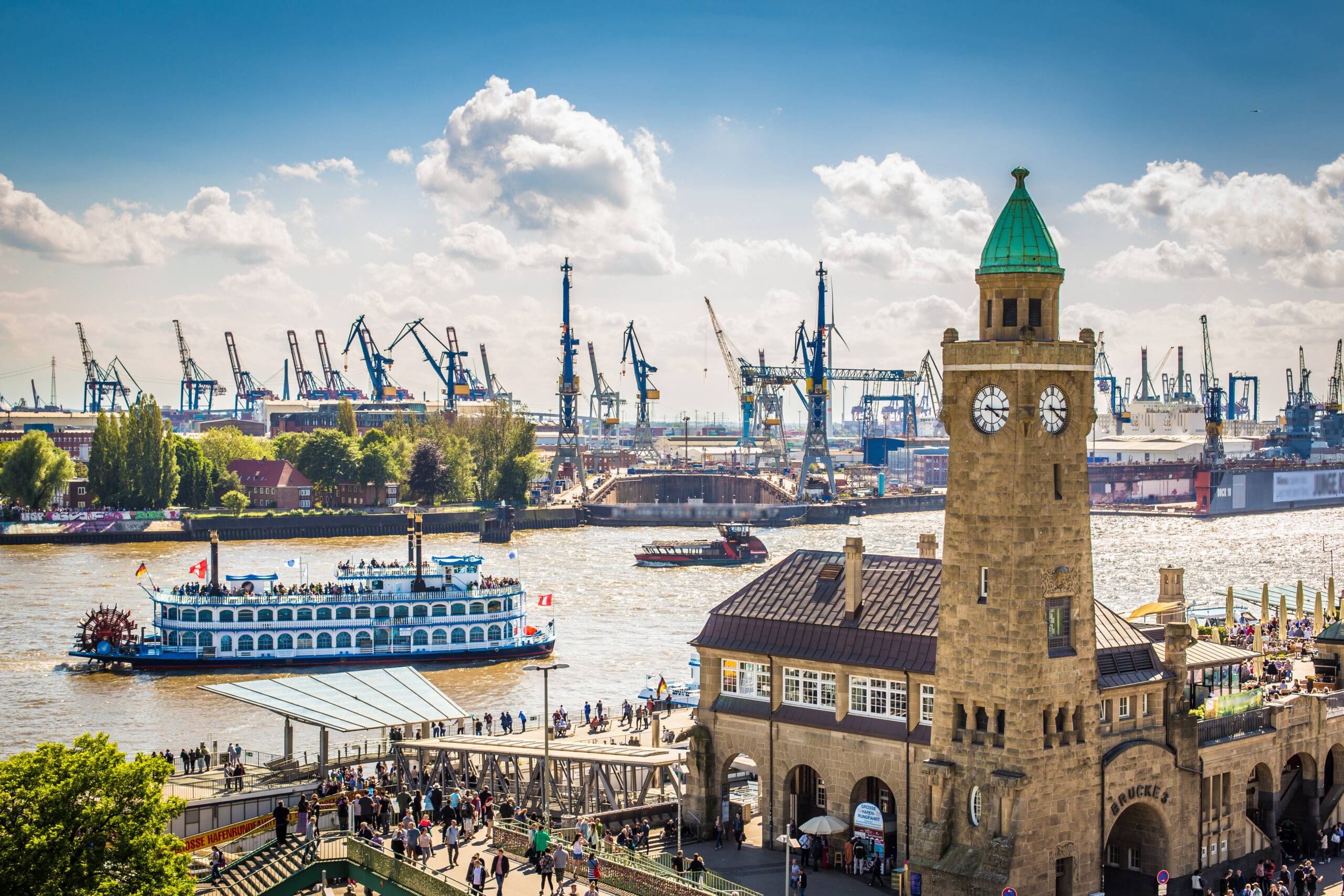 Panoramablick auf den Hamburger Hafen mit Landungsbruecken und Schaufelradschiff bei sonnigem Wetter – idealer Programmpunkt bei einer Klassenfahrt Hamburg