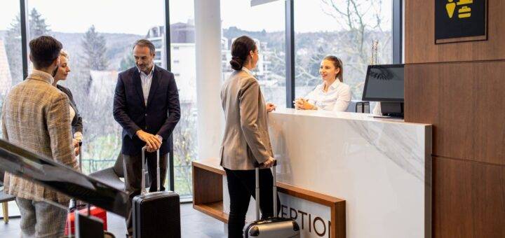 Businessgäste checken im Tagungshotel NRW ein – moderner Empfangsbereich mit Blick ins Grüne