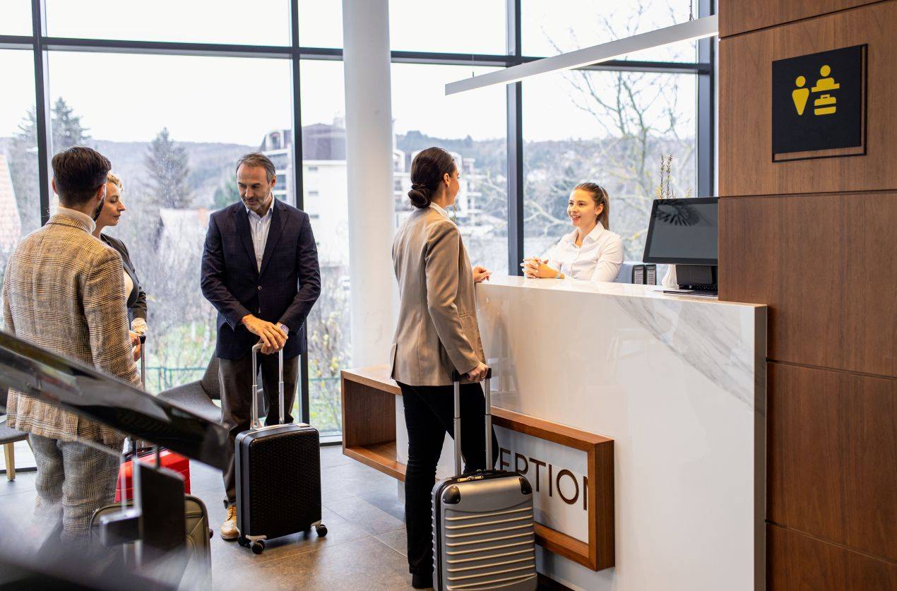 Businessgäste checken im Tagungshotel NRW ein – moderner Empfangsbereich mit Blick ins Grüne