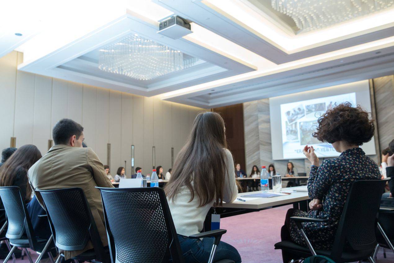 Teilnehmer hören im Tagungshotel NRW einer Business-Präsentation zu – moderner Konferenzsaal mit Fokus auf Kommunikation