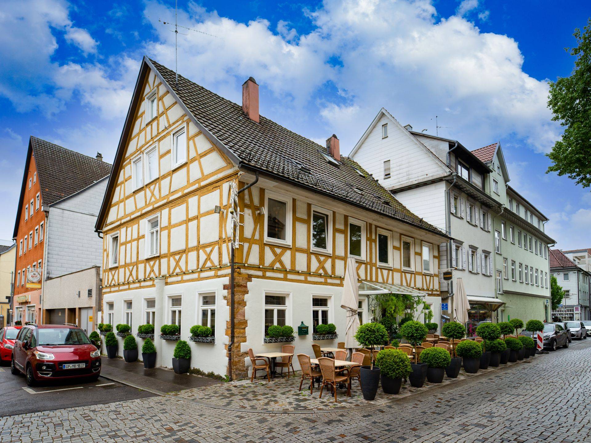 Fachwerkhaus mit Strassencafe in der Altstadt von Goeppingen bei schoenem Wetter