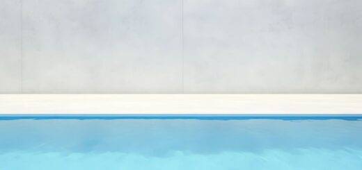 Klarer Swimmingpool vor heller Betonwand – modernes Symbol fuer Freizeit mit Gegenstromanlage Pool