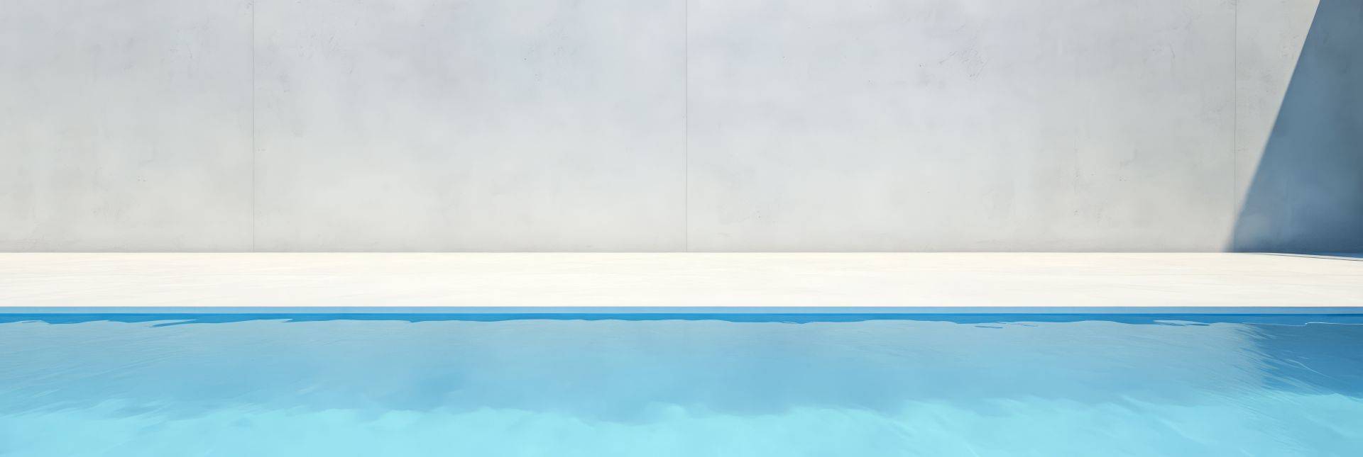 Klarer Swimmingpool vor heller Betonwand – modernes Symbol fuer Freizeit mit Gegenstromanlage Pool