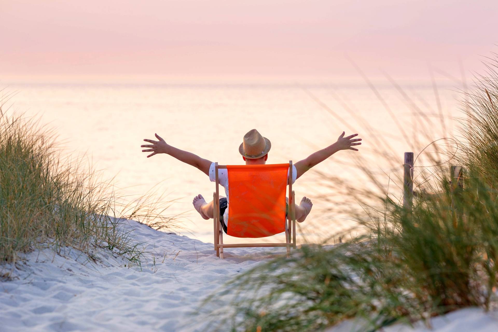 Person sitzt im Liegestuhl am Strand | Heilerde
