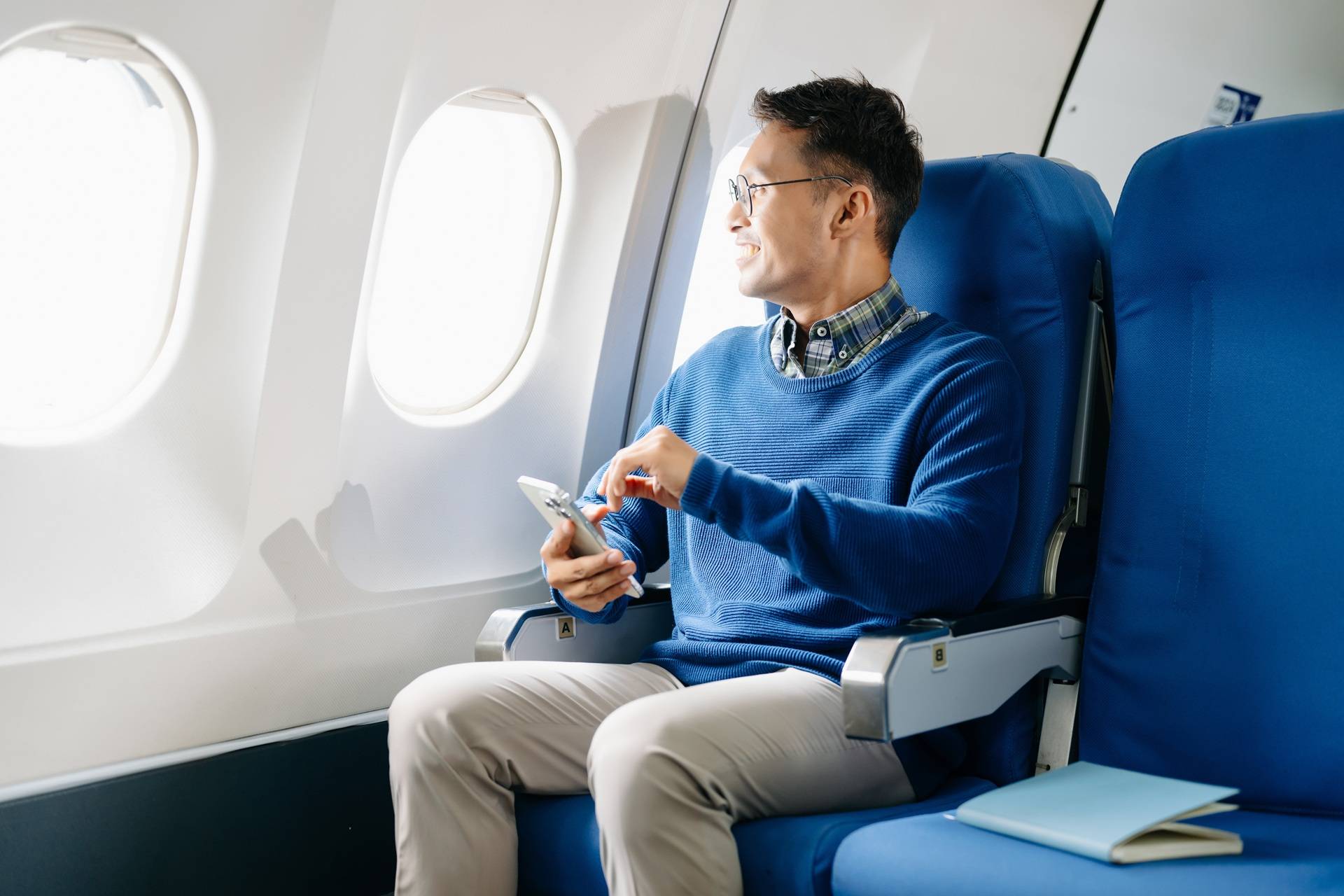 Mann sitzt im Flugzeug und schaut aus dem Fenster | Escort Düsseldorf