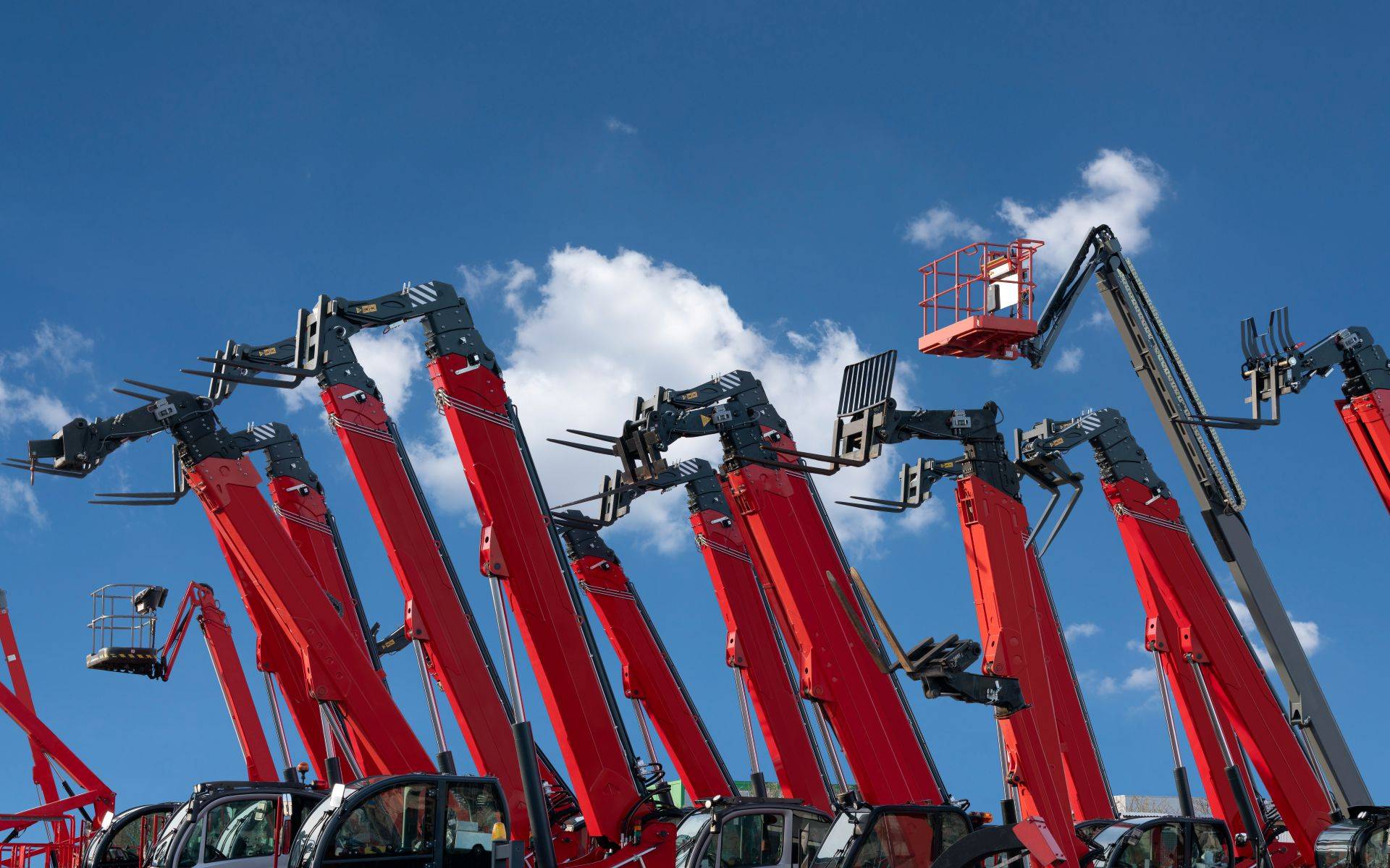 Mehrere rote Lkw-Arbeitsbühnen mit ausgefahrenen Armen